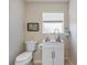 Cozy bathroom features a toilet, sink, and window, ideal for guests at 25942 Risen Star Dr, Wesley Chapel, FL 33544