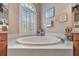 Comfortable bathroom showcasing a garden tub with tiled surround and nautical decorations at 25942 Risen Star Dr, Wesley Chapel, FL 33544