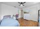 Bright bedroom features wood floors, a ceiling fan, a dresser and a desk at 25942 Risen Star Dr, Wesley Chapel, FL 33544