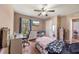Cozy bedroom features wood floors, a ceiling fan, and a window with natural light and a flat screen TV at 25942 Risen Star Dr, Wesley Chapel, FL 33544