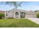 Charming single-story home featuring a well-manicured lawn and an attached two-car garage at 25942 Risen Star Dr, Wesley Chapel, FL 33544