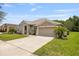 Attractive home with well-kept lawn, a large driveway and two car garage in a suburban setting at 25942 Risen Star Dr, Wesley Chapel, FL 33544