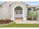 Inviting front entrance with double doors, decorative wreaths, and charming landscaping at 25942 Risen Star Dr, Wesley Chapel, FL 33544