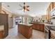 Well-lit kitchen featuring tiled flooring, wood cabinets, a center island, and ample counter space at 25942 Risen Star Dr, Wesley Chapel, FL 33544