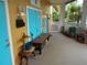 Covered porch with teal doors, wooden bench, and exterior lighting at 2624 54Th S St, Gulfport, FL 33707