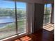 Bedroom featuring hardwood floors, large windows with fountain views, and a private balcony at 2625 State Road 590 # 2832, Clearwater, FL 33759