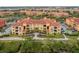 Aerial view highlighting building's balconies and manicured landscaping, with a glimpse of the waterfront at 2739 Via Capri # 1011, Clearwater, FL 33764