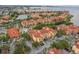 An aerial view showcasing the condo community, the beautiful red tile roofs, a pool, and its lakeside location at 2739 Via Capri # 1011, Clearwater, FL 33764