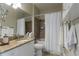 Bathroom features granite countertops, neutral tile, and shower/tub combo with a white shower curtain at 2739 Via Capri # 1011, Clearwater, FL 33764