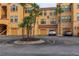A view of the yellow condo building with garages and tropical landscaping at 2739 Via Capri # 1011, Clearwater, FL 33764