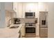 Modern kitchen with stainless steel appliances and white cabinets at 2739 Via Capri # 1011, Clearwater, FL 33764