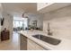 Modern kitchen with stainless steel dishwasher, bright countertops, and an open view to the dining and living areas at 2739 Via Capri # 1011, Clearwater, FL 33764