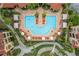 A beautiful overhead shot of the pool area with lounge chairs, umbrellas, and a unique, inviting pool design at 2739 Via Capri # 1011, Clearwater, FL 33764