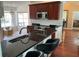 Modern kitchen with stainless appliances, granite counters, dark wood cabinets and a breakfast bar at 2861 Penridge Dr, Palm Harbor, FL 34684