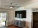 Cozy living room with ceiling fan, mounted TV, and sliding glass doors to the outdoor area at 2861 Penridge Dr, Palm Harbor, FL 34684