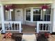 Cozy front porch decorated with hanging floral baskets, seating, and a welcoming front door at 2861 Penridge Dr, Palm Harbor, FL 34684