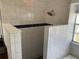 Walk-in shower with modern white tile, dark accent stripe, and a rain shower head at 2861 Penridge Dr, Palm Harbor, FL 34684