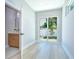 Bedroom with light wood-look flooring, a sliding glass door to the backyard, and half-bath access at 3004 W Abdella St, Tampa, FL 33607