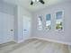 Clean bedroom with light hardwood floors, modern ceiling fan, and three bright windows at 3004 W Abdella St, Tampa, FL 33607