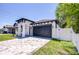 Modern home exterior with a paved driveway, black trim, and lush green lawn at 3004 W Abdella St, Tampa, FL 33607