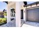 Covered porch entrance to a contemporary home with stone steps and modern black door at 3004 W Abdella St, Tampa, FL 33607