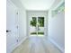 Bright hallway with light wood-look flooring, a sliding glass door to the backyard and a side window at 3004 W Abdella St, Tampa, FL 33607