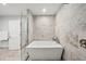 Modern bathroom featuring a soaking tub and glass-enclosed shower with premium fixtures and neutral tile at 301 2Nd N St # 15, St Petersburg, FL 33701