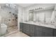 Modern bathroom featuring double vanity sinks, a large mirror, and a glass-enclosed shower, skylight above the shower at 301 2Nd N St # 15, St Petersburg, FL 33701
