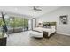 Bright primary bedroom featuring a ceiling fan, private balcony, and wood-look tile flooring at 301 2Nd N St # 15, St Petersburg, FL 33701