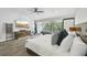 Bright primary bedroom featuring a private balcony, television, and wood-look tile flooring at 301 2Nd N St # 15, St Petersburg, FL 33701