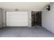 View of a gray-tone carport with white garage doors, an entry gate, and brick pavers at 301 2Nd N St # 15, St Petersburg, FL 33701