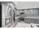 Modern kitchen with stainless steel appliances, gray cabinetry, marble countertops and tile backsplash at 301 2Nd N St # 15, St Petersburg, FL 33701