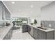 Open concept kitchen with gray cabinets, granite counters, stainless appliances, and view to a seating area and landscaped yard at 301 2Nd N St # 15, St Petersburg, FL 33701