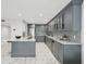 Modern kitchen with marble countertops, gray cabinetry, stainless appliances, island with seating, and a wine fridge at 301 2Nd N St # 15, St Petersburg, FL 33701