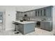 Gourmet kitchen with marble countertops, gray cabinetry, stainless appliances, island with seating, and a wine fridge at 301 2Nd N St # 15, St Petersburg, FL 33701