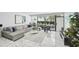 Living room with a gray sofa, modern decor, marble floors, and view of the outdoor patio and barbecue at 301 2Nd N St # 15, St Petersburg, FL 33701