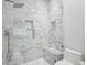 Modern glass enclosed shower featuring marble tiling with built in shelves and a shower seat at 301 2Nd N St # 15, St Petersburg, FL 33701