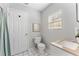 Bathroom featuring a toilet, sink, window, and shower/bath combo at 3125 W Fielder St, Tampa, FL 33611