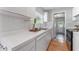 Bright kitchen with white cabinets, stainless steel sink, and white backsplash at 3125 W Fielder St, Tampa, FL 33611