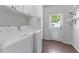 Well-lit laundry room with modern washer and dryer, storage cabinets, and outdoor access at 3125 W Fielder St, Tampa, FL 33611