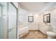 Bathroom with dual vanity, soaking tub, and glass-enclosed shower at 3305 Blythe Ave, Spring Hill, FL 34609