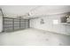 Spacious two-car garage with a gray door, white walls, and plenty of storage space at 3305 Blythe Ave, Spring Hill, FL 34609