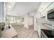 Open-concept kitchen with granite countertops and stainless appliances flows into bright dining area at 3305 Blythe Ave, Spring Hill, FL 34609