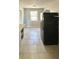Functional kitchen area with black refrigerator, tile flooring, and ample natural light at 4214 Fairfield S Ave, St Petersburg, FL 33711