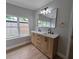 Bathroom featuring a double vanity with light wood cabinets, modern fixtures, and a large mirror at 4434 Bass St, Tampa, FL 33617