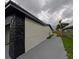 Exterior view along the driveway featuring the home's white facade and decorative rockwork accents at 4434 Bass St, Tampa, FL 33617