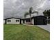 Charming single-story home with a well-manicured lawn and decorative palm tree in the front yard at 4434 Bass St, Tampa, FL 33617