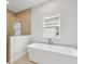 Modern bathroom with a soaking tub, glass shower, and a large window at 4523 Foley Grove Dr, Valrico, FL 33596