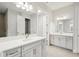 Bathroom with double vanities, large mirrors, light grey cabinetry, and modern fixtures at 4523 Foley Grove Dr, Valrico, FL 33596