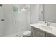 Bathroom featuring glass shower, white tiles, grey vanity, and modern fixtures at 4523 Foley Grove Dr, Valrico, FL 33596
